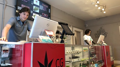 In this Wednesday, March 6, 2019 photo, Korbin Osborn, left, works as a cannabis adviser at a medical marijuana dispensary in Santa Fe, N.M.