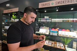 In this March 21, 2019, photo, Gus Dabais looks over CBD products he sells at his Sidewalk Wellness store in San Francisco.