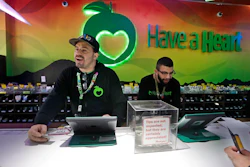 In this March 28, 2019, photo, employees Dan Giroux, left, and Dustin Barrington ring up sales for customers at a marijuana shop in Seattle.