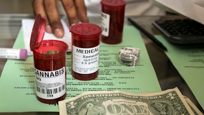 In this May 14, 2013, file photo, medical marijuana prescription vials are filled at a medical marijuana dispensary in Los Angeles.