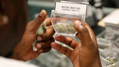 In this April 20, 2018, file photo, a customer shops for marijuana at the Exhale Nevada dispensary in Las Vegas.