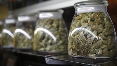 This Friday, Dec. 18, 2015, photo shows jars of marijuana buds in a LivWell outlet in Denver.