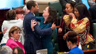 Illinois deputy governor Christian Mitchell and Illinois state Rep. Kelly Cassidy, D-Chicago, embrace as they celebrate the 66-47 vote in the Illinois House for a bill to legalize recreational marijuana use Friday, May 31, 2019. The vote sends the bill to Gov. J.B. Pritzker who indicated he will sign it.