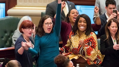 Illinois state Rep. Kelly Cassidy, D-Chicago, throws her fist in the air as the final votes come in for a bill to legalize recreational marijuana use, Friday, May 31, 2019.