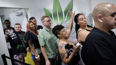 In this July 1, 2017, file photo, people wait in line at the Essence cannabis dispensary in Las Vegas. Nevada is set to pioneer a law to prevent job-seekers from being immediately rejected for work based on a positive marijuana test.