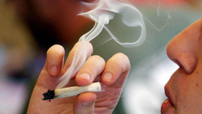 In this April 20, 2016, file photo, a man smokes a marijuana joint at a party celebrating weed in Seattle. Legalizing recreational marijuana for U.S. adults may have led to a slight decline in teen use. That’s according to research published Monday, July 8, 2019, in JAMA Pediatrics.