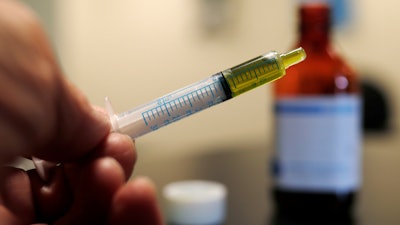 In this Nov. 6, 2017, file photo, a syringe with a dose of CBD oil is shown in a research laboratory in Fort Collins, Colo.