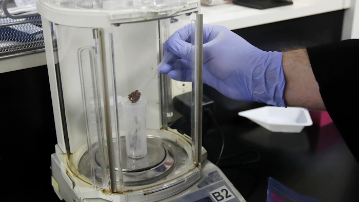 In this Friday, Aug. 16, 2019, photo, chemist David Dawson pours pieces of a cannabis-infused chocolate bar into a vial as he demonstrates testing for THC and other chemicals at CW Analytical Laboratories in Oakland, Calif. Chemists are trying to solve a scientific mystery involving marijuana brownies. Chocolate seems to throw off test results for potency. That could be dangerous for consumers looking to relax, not hallucinate.