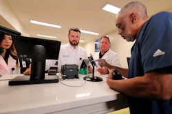Alex Domino, right, the first ever person to receive medical marijuana in Louisiana, purchases his dose at Capitol Wellness Solutions, in Baton Rouge, La., Tuesday, Aug. 6, 2019.