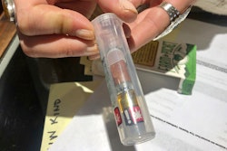 In this photo taken Sept. 20, 2019, Cameron Moore, general manager of Bridge City Collective in Portland, Ore., holds a vape cartridge that's on sale at the dispensary. The company had a 31% drop in sales of vape cartridges that hold the oil that vaporizes when heated. Vaping products are taking a hit as health experts scramble to determine what’s causing a mysterious lung disease.