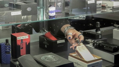 In this Oct. 8, 2019 file photo, a vaping store owner works in one of her locations in New York.