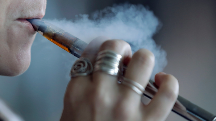 In this Oct. 4, 2019, file photo, a woman using an electronic cigarette exhales a puff of smoke in Mayfield Heights, Ohio.