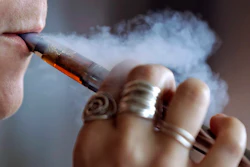 In this Friday, Oct. 4, 2019, file photo, a woman using an electronic cigarette exhales a puff of smoke in Mayfield Heights, Ohio.