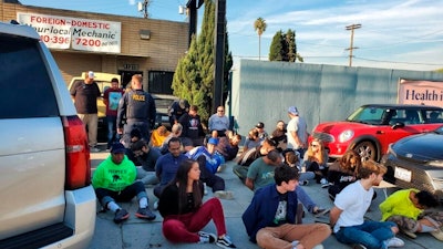 This Dec. 12, 2019, photo provided by the Department of Consumer Affairs shows suspects from Save Greens Cannabis dispensary being taken into custody by law enforcement for operating without a state license in Los Angeles.