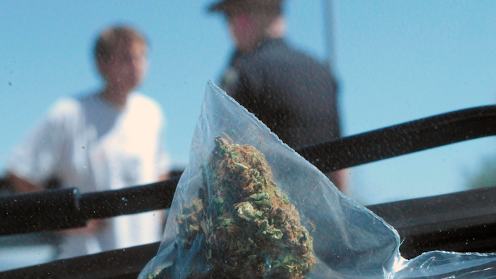 In this June 20, 2012, file photo, Idaho State Police Trooper Justin Klitch, right, makes a stop and charges the driver with possession of marijuana after leaving Oregon, in Fruitland, Idaho.