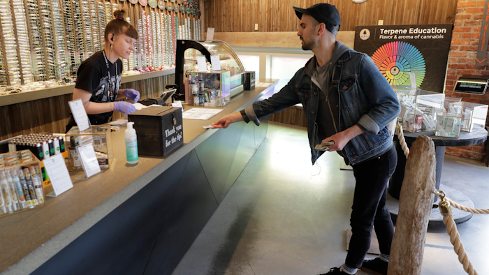 Christopher Ellis shows his identification at The Reef Capitol Hill, Seattle, March 24, 2020.