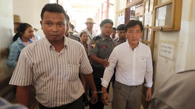 Shein Latt, left, leaves a local court after being arrested for operating a marijuana plantation in Ngazun Township, Myanmar, May 7, 2019.