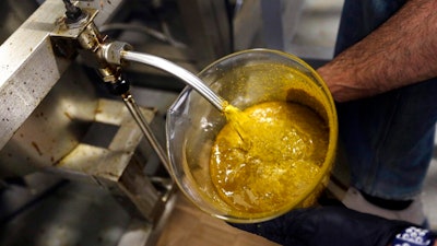 In this April 24, 2018, file photo, the first rendering from hemp plants extracted from a super critical CO2 extraction device on its' way to becoming fully refined CBD oil spurts into a large beaker at New Earth Biosciences in Salem, Ore. Sens. Ron Wyden and Jeff Merkley on Tuesday, Jan. 15, 2019, urged the head of the U.S. Food and Drug Administration to update federal regulations to permit interstate commerce of food products containing a key non-psychoactive ingredient of cannabis.