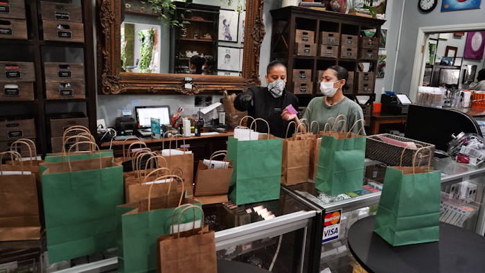 Budtenders wearing protective masks prepare orders for customers at the Higher Path cannabis dispensary, Sherman Oaks, Los Angeles, April 16, 2020.