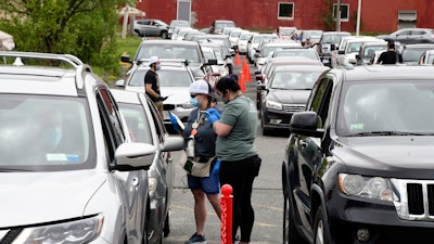 Amanda Toma and Ashley Brodeur work in the parking lot of Berkshire Roots in Pittsfield, Mass., May 25, 2020.