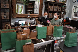Budtenders wearing protective masks prepare orders for customers at the Higher Path cannabis dispensary, Sherman Oaks, Los Angeles, April 16, 2020.