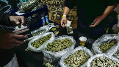A vendor makes change for a customer at a cannabis marketplace in Los Angeles, April 15, 2019.