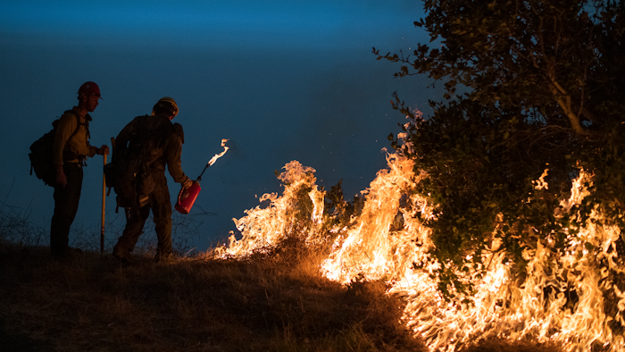 In this Sept. 11, 2020, file photo, firefighters light a controlled burn along Nacimiento-Fergusson Road to help contain the Dolan Fire near Big Sur, Calif. Rain showers fell Thursday, Sept. 24, 2020, on the northwestern edges of fire-ravaged California but forecasters warned residents to not be fooled: a new round of hot, dry and windy weather is expected by the weekend.