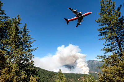 In this Sept. 17, 2020, file photo, an air tanker prepares to drop retardant while battling the August Complex Fire in the Mendocino National Forest, Calif. Rain showers fell Thursday, Sept. 24, 2020, on the northwestern edges of fire-ravaged California but forecasters warned residents to not be fooled: a new round of hot, dry and windy weather is expected by the weekend.