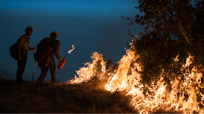 In this Sept. 11, 2020, file photo, firefighters light a controlled burn along Nacimiento-Fergusson Road to help contain the Dolan Fire near Big Sur, Calif. Rain showers fell Thursday, Sept. 24, 2020, on the northwestern edges of fire-ravaged California but forecasters warned residents to not be fooled: a new round of hot, dry and windy weather is expected by the weekend.