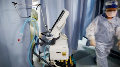 A nurse pulls a ventilator into an exam room at St. Joseph's Hospital in Yonkers, N.Y., April 20, 2020.