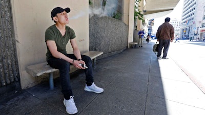 Jacky Chan takes a break from his job at a smoke shop in San Francisco, June 17, 2019.