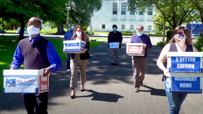 Volunteers deliver boxes containing signed petitions to the Oregon Secretary of State's office in Salem, June 26, 2020.