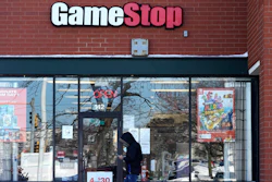 In this Jan. 28, 2021 file photo, a customer checks on his cellphone as he walks to a GameStop store in Vernon Hills, Ill.