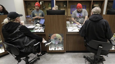 Medical marijuana patients talk with staff members at the Rise cannabis store, Mundelein, Ill., Dec. 26, 2019.