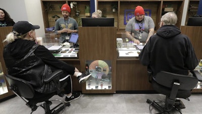 Medical marijuana patients talk with staff members at the Rise cannabis store, Mundelein, Ill., Dec. 26, 2019.