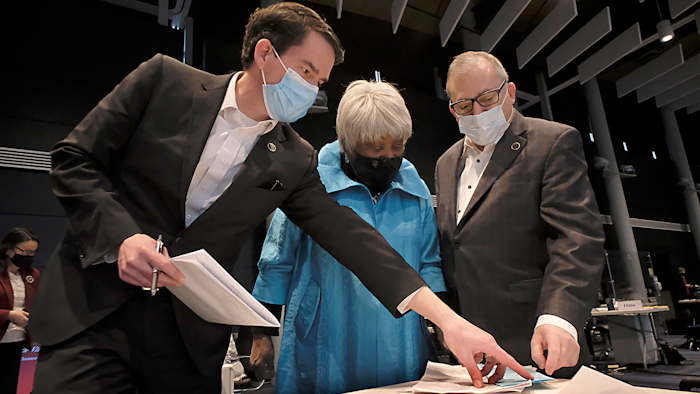 Sen. Jeremy McPike, D-Prince William, left, Sen. Louise Lucas, D-Portsmouth, center and Sen. Adam Ebbin, D-Alexandria, right, confer on marijuana legislation before the floor session of the Virginia Senate, which is meeting inside the Science Museum of Virginia in Richmond, Va., Saturday, Feb. 27, 2021.