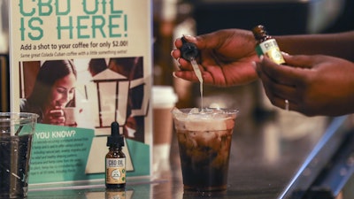 A worker adds CBD oil to a drink at a coffee shop in Fort Lauderdale, Fla., Jan. 4, 2018.