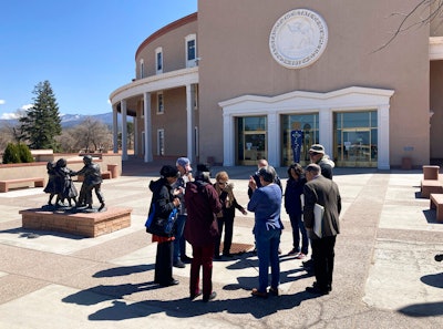 A group prays outside the New Mexico Capitol building, Santa Fe, March 30, 2021.