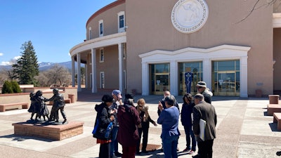 A group prays outside the New Mexico Capitol building, Santa Fe, March 30, 2021.