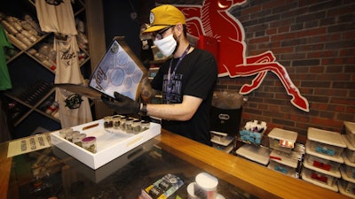 Ben Prater checks over his stock at his marijuana dispensary, Denver, April 8, 2020.