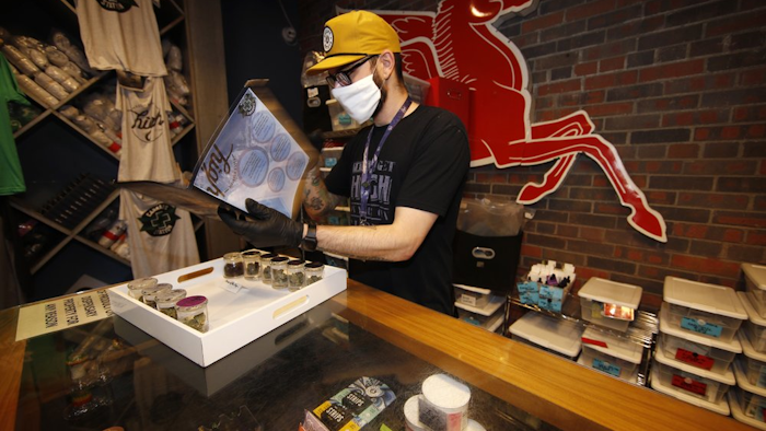 Ben Prater checks over his stock at his marijuana dispensary, Denver, April 8, 2020.