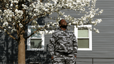 Nikko Ross stands for a portrait at his home, Thursday, April 15, 2021, in Evanston, Ill. Acknowledging past racist policies, Evanston is giving eligible Black residents $25,000 housing grants for down payments, repairs or existing mortgages this year. He'll seek a grant, either for his down payment, or for his mother to repair her six-bedroom house.