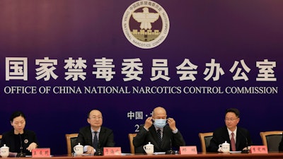 Deng Ming, deputy director of China's National Narcotics Control Commission, removes his mask for a press conference in Beijing, May 11, 2021.