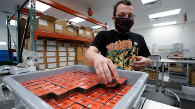Bill Mathis packages THC products in Hazel Park, Mich., April 29, 2021.