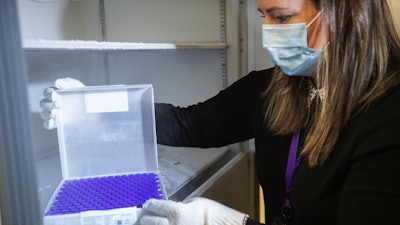 University of Washington Medical Center Pharmacy Manager Christine Meyer puts a tray of doses of the Pfizer-BioNTech COVID-19 vaccine into the deep freeze after the vaccine arrived at the University of Washington Medical Center's Montlake campus, Seattle, Dec. 14, 2020.