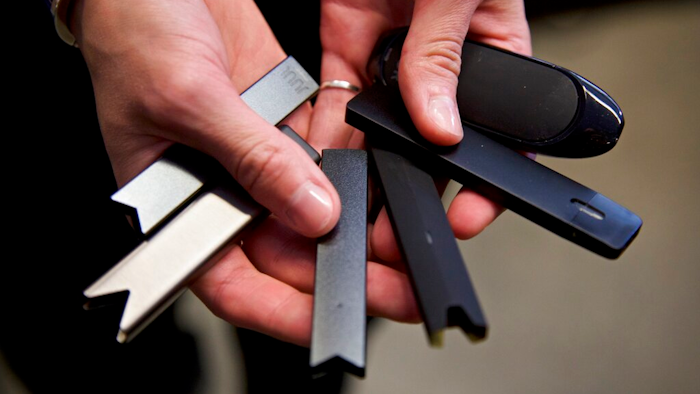 A researcher holds vape pens in a laboratory in Portland, Ore., April 16, 2019.
