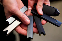 A researcher holds vape pens in a laboratory in Portland, Ore., April 16, 2019.