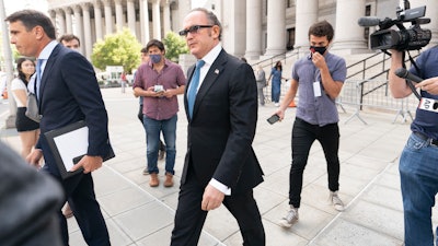 Igor Fruman, center, is surrounded by reporters as he leaves in Federal court in Manhattan with his attorney Todd Blanche, left, Friday, Sept. 10, 2021. The Soviet-born Florida businessman who helped Rudy Giuliani seek damaging information about Joe Biden in Ukraine when Biden was running for president pleaded guilty in a case involving illegal campaign contributions.