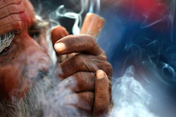 A Hindu holy man smokes marijuana in the courtyard of Pashupatinath temple during Shivratri festival, Kathmandu, Nepal, March 11, 2021.