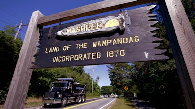 A wooden sign marks the location of Mashpee Wampanoag tribal lands along a road in Massachusetts, June 25, 2018.